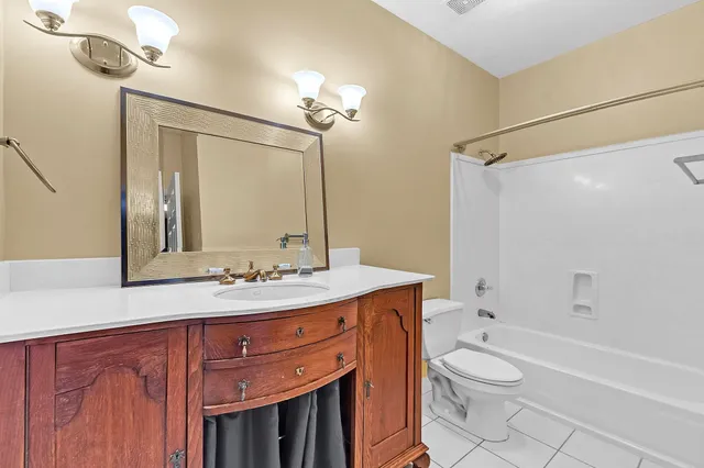 a bathroom with a sink a toilet a mirror and shower