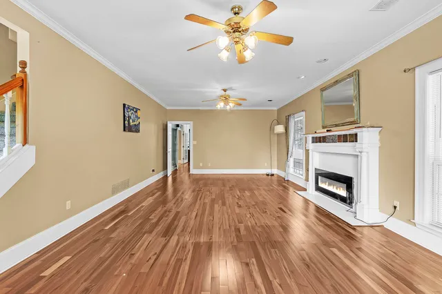 a view of empty room with wooden floor and fireplace