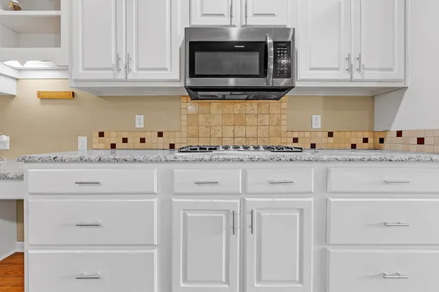 a kitchen with white cabinets appliances and a sink