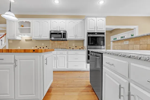 a kitchen with stainless steel appliances granite countertop a stove and a refrigerator