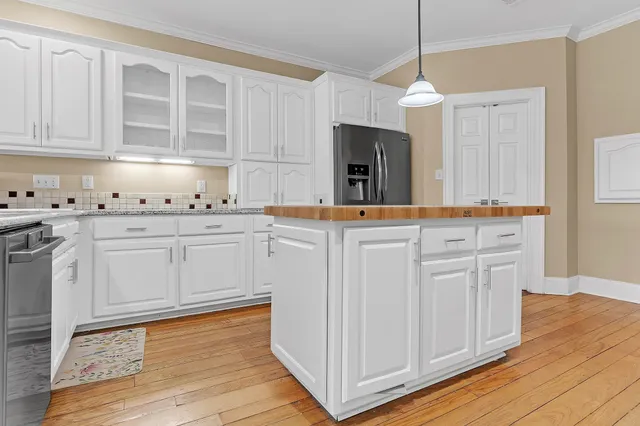 a kitchen with granite countertop white cabinets and stainless steel appliances