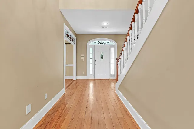 a view of a hallway with wooden floor and staircase