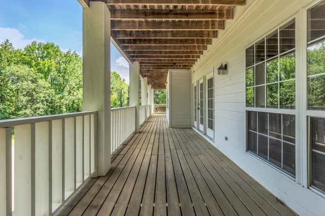 a view of balcony with wooden floor and fence