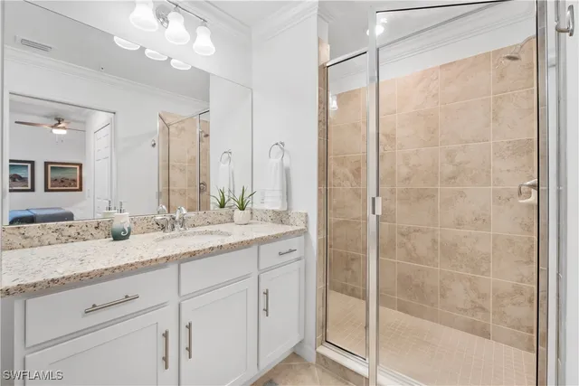 a bathroom with a granite countertop sink two mirror and shower