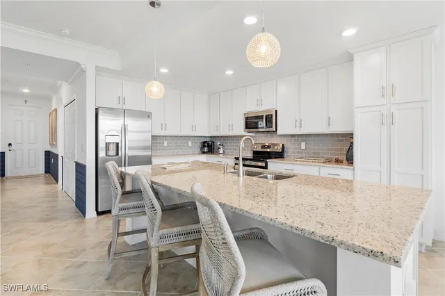 a kitchen with stainless steel appliances granite countertop a sink refrigerator and cabinets