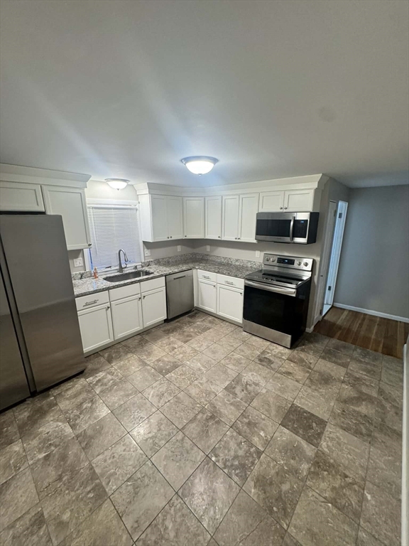 382 Holyoke Street Ludlow, MA 01056 - Photo 9 of 17 a large kitchen with a stove a refrigerator and a sink