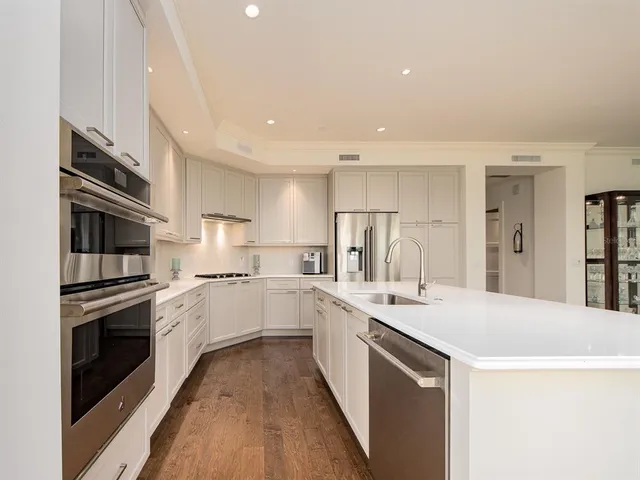 a kitchen with white cabinets appliances and sink