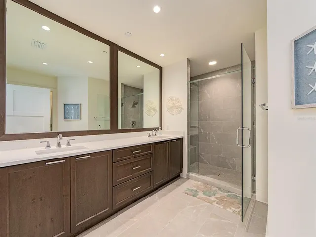 a bathroom with a double vanity sink mirror and shower