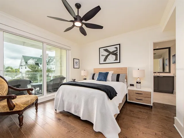 a bedroom with a bed and large windows