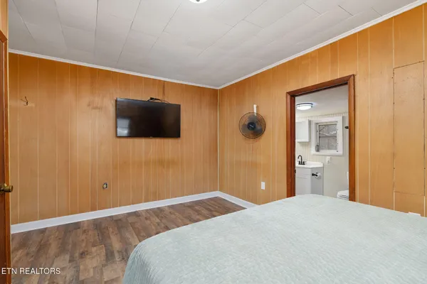 a bedroom with a bed and wooden floor