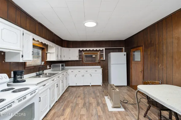 a kitchen with stainless steel appliances granite countertop a stove a sink dishwasher and a refrigerator with wooden cabinets