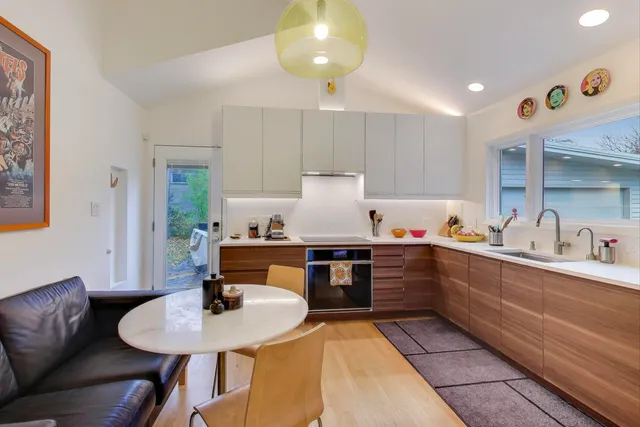 a kitchen with sink refrigerator dining table and chairs