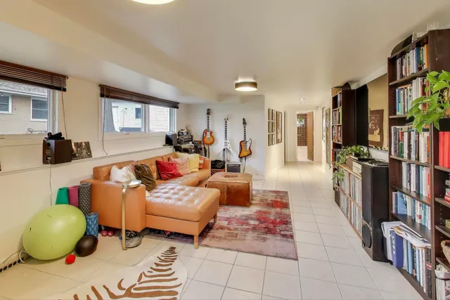 a living room with furniture and a book shelf