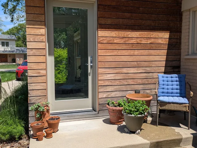 a view of a entryway door of the house with potted plants