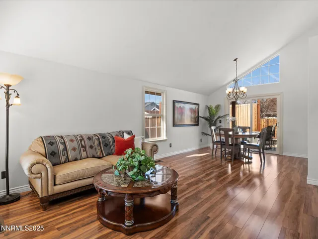 a kitchen with stainless steel appliances kitchen island granite countertop a stove a sink a dining table and chairs with wooden floor