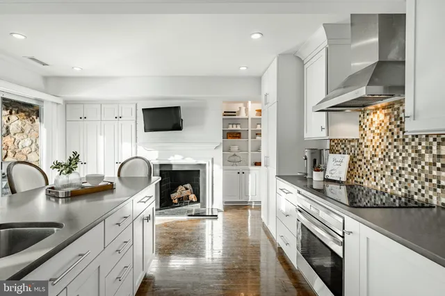 a kitchen with stainless steel appliances kitchen island granite countertop a stove and white cabinets