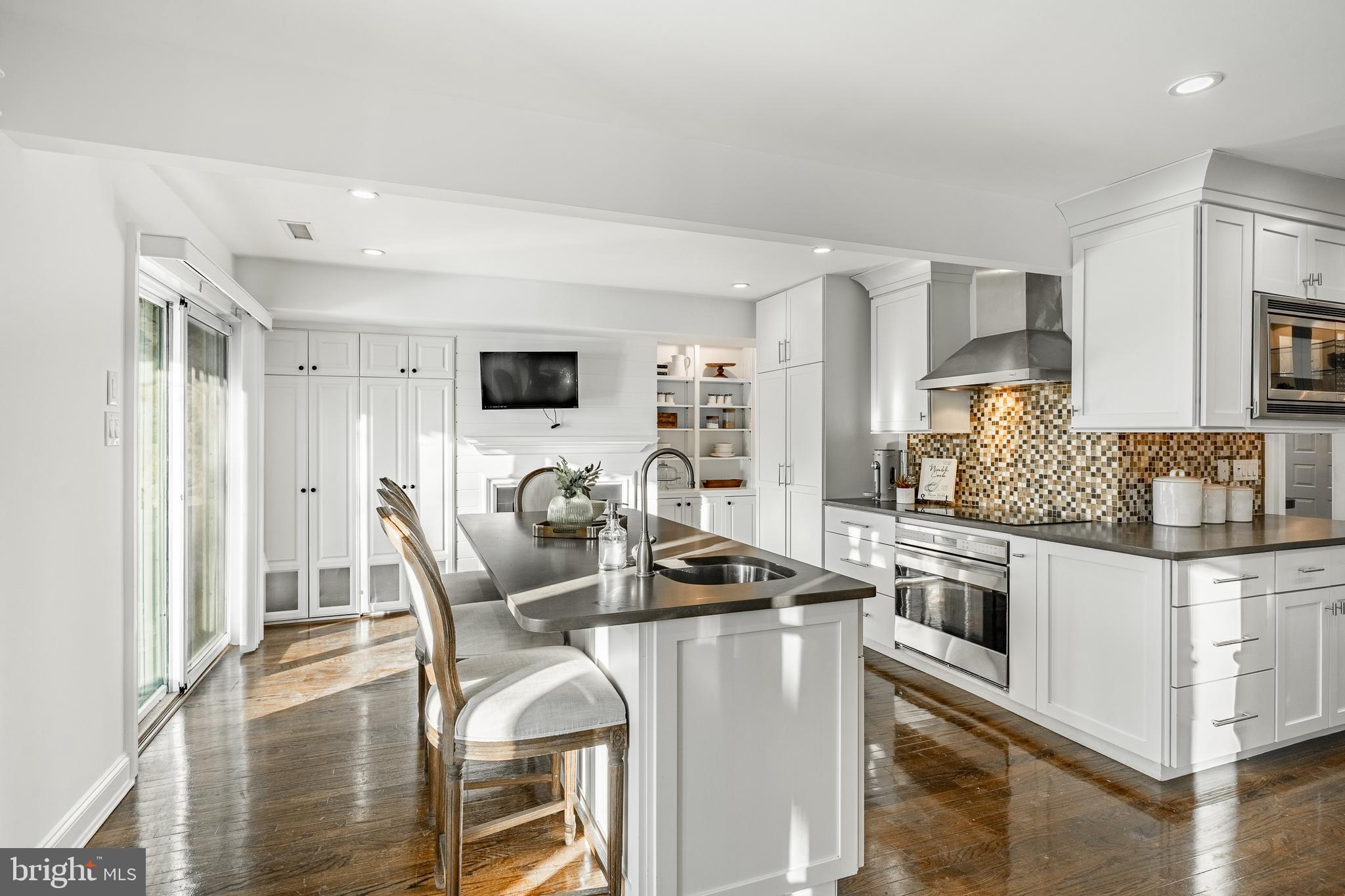 1256 Round Hill Road Bryn Mawr, PA 19010 - Photo 24 of 65 a kitchen with stainless steel appliances granite countertop a stove top oven a refrigerator a sink and white cabinets with wooden floor