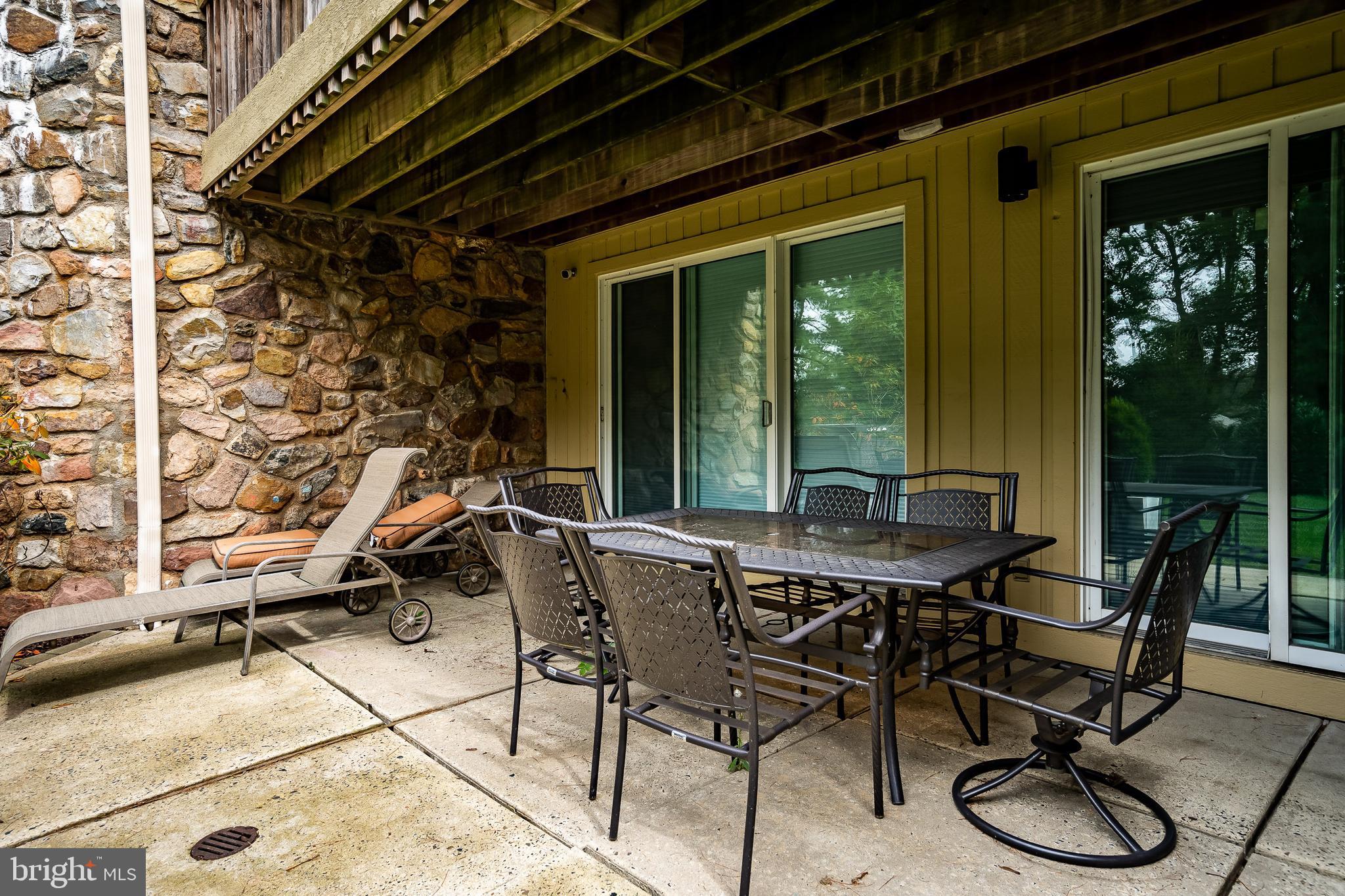 1256 Round Hill Road Bryn Mawr, PA 19010 - Photo 62 of 65 a patio with table and chairs and potted plants