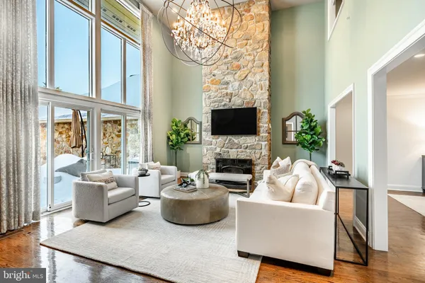 a living room with furniture a chandelier and a flat screen tv