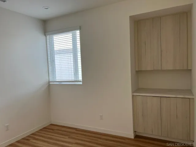 a view of a room with wooden floor and cabinet