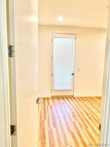 a view of a room with wooden floor and a bathroom