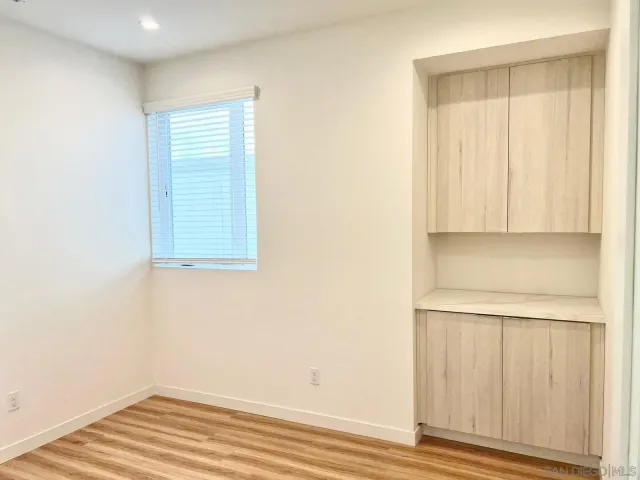 a view of a room with wooden floor and cabinet
