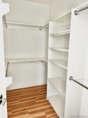 a view of walk in closet with empty racks