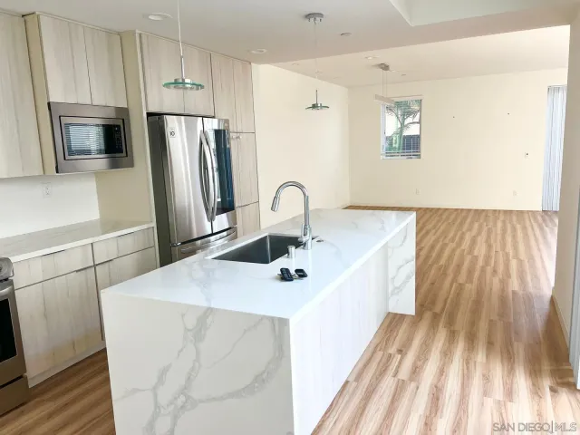 a kitchen with a sink a refrigerator and a fireplace