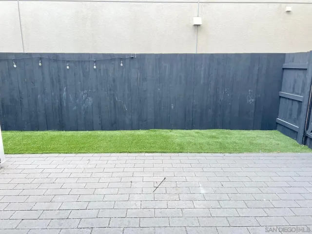 a view of backyard and wooden fence