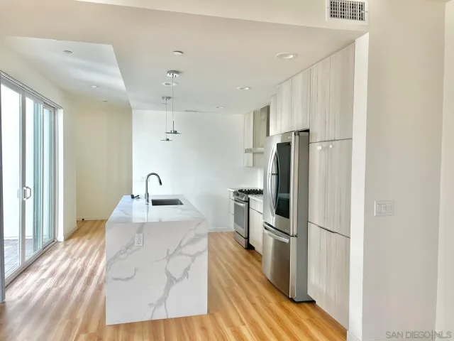 a kitchen with granite countertop a refrigerator and a sink