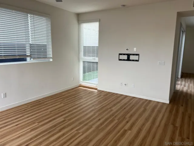 a view of a room with wooden floor and a window