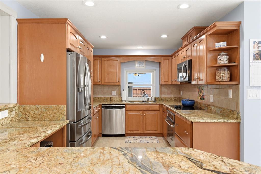 7432 Sparkling Lake Road Orlando, FL 32819 - Photo 12 of 54 a kitchen with stainless steel appliances granite countertop a sink stove and refrigerator