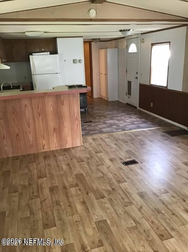218 Violet Avenue Interlachen, FL 32148 - Photo 2 of 7 an empty room with wooden floor and windows