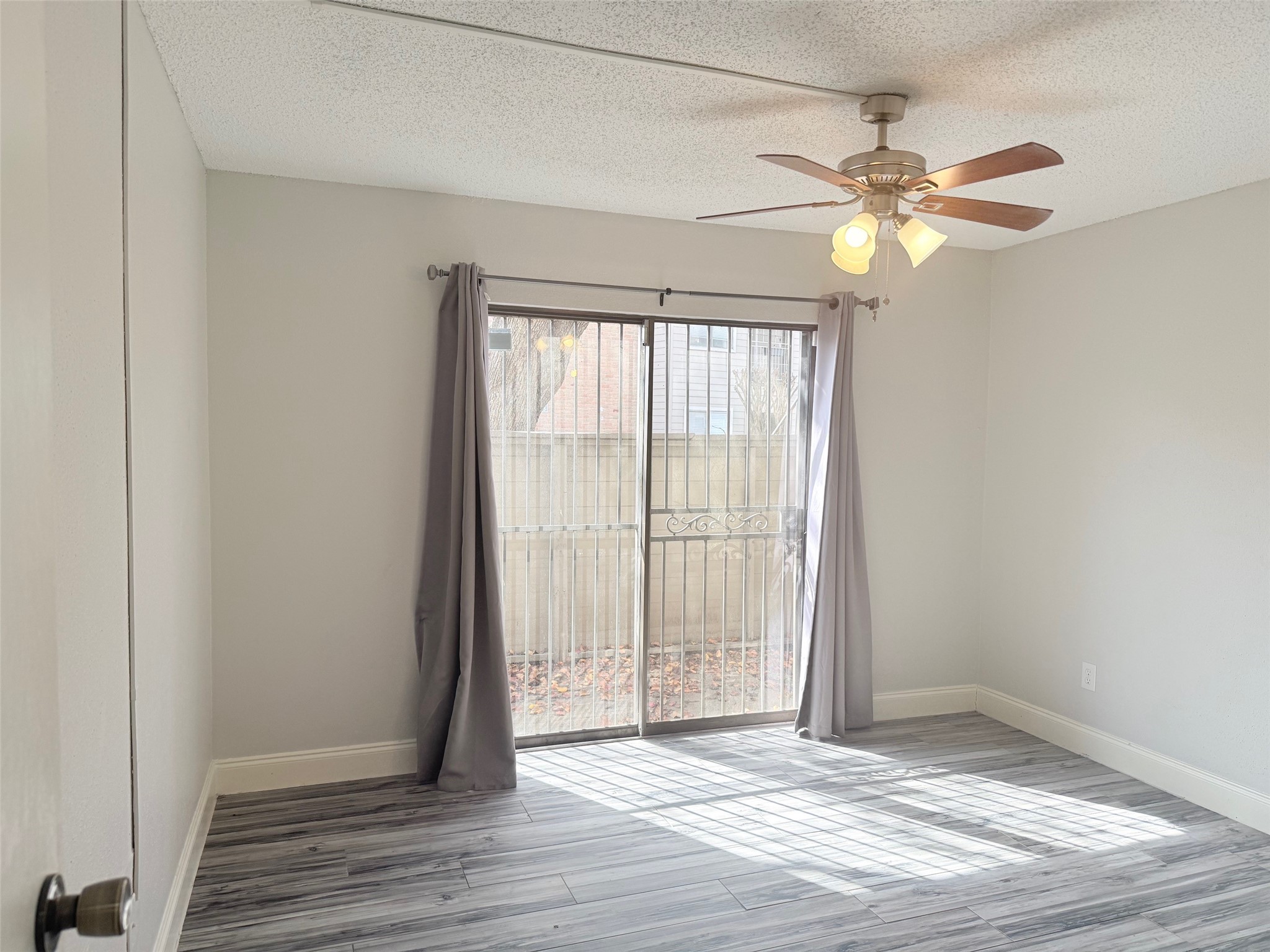 6701 Sands Point Drive, Unit 48 Houston, TX 77074 - Photo 17 of 30 an empty room with wooden floor fan and windows