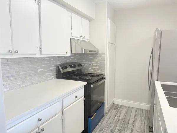 a kitchen with a sink stove and refrigerator