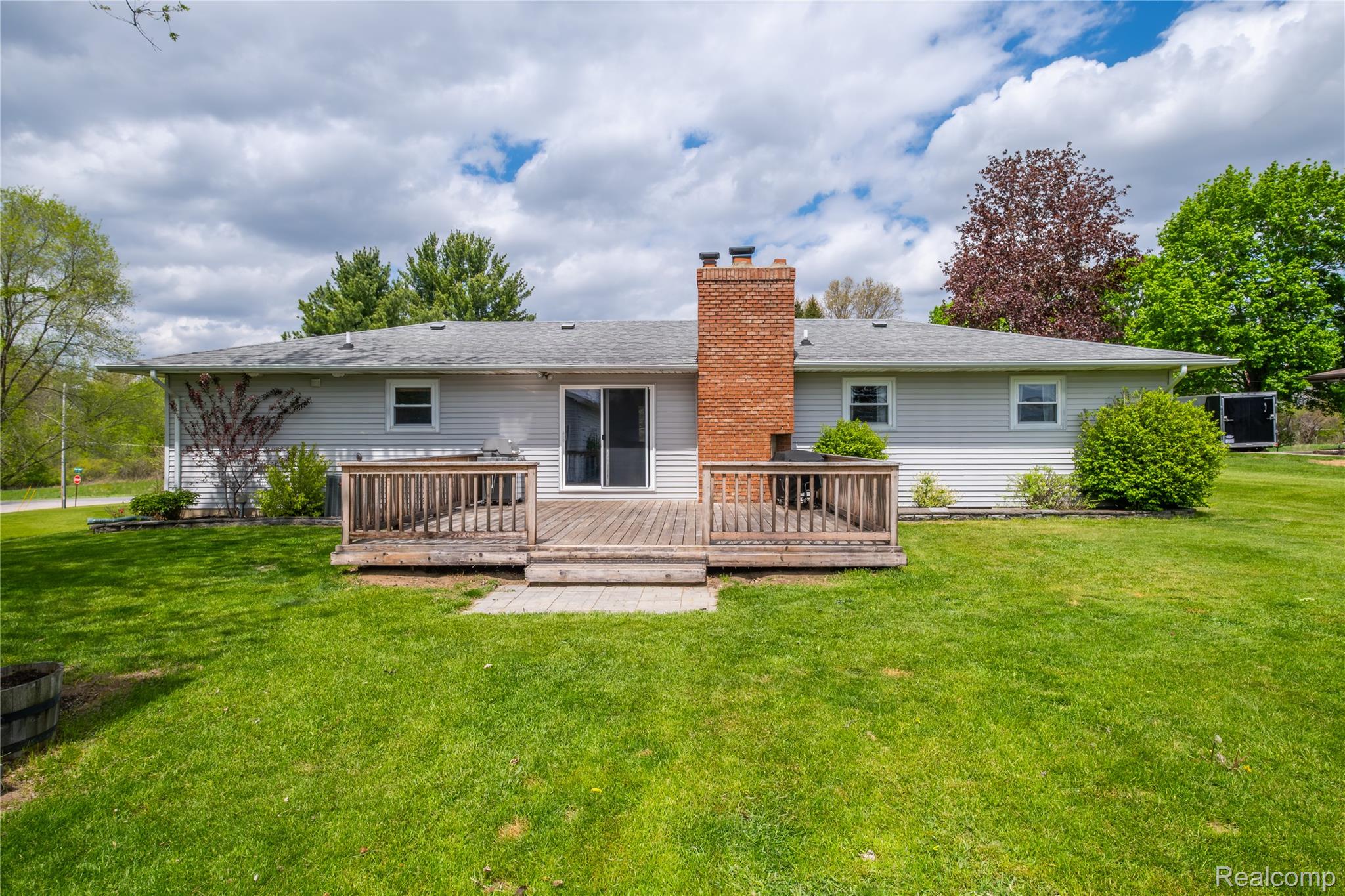 11430 Silver Lake Road Byron, MI 48418 - Photo 24 of 32 Back of house with a lawn, a wooden deck, and a chimney