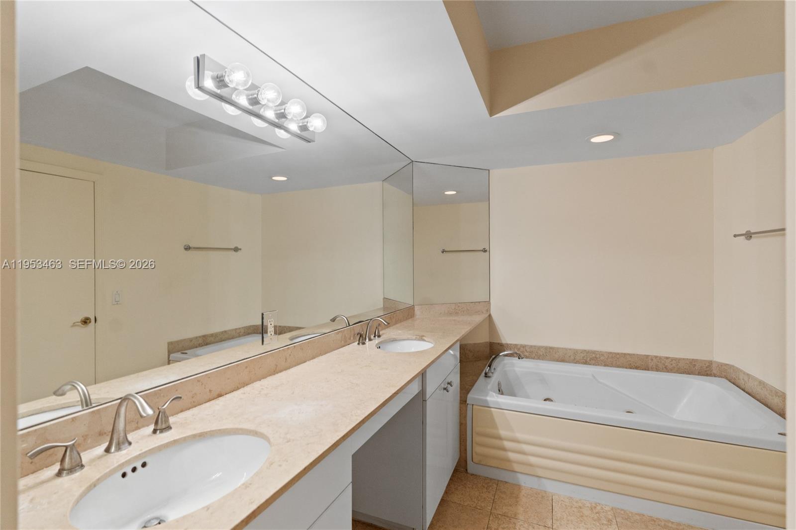 4775 Collins Avenue, Unit 507 Miami Beach, FL 33140 - Photo 25 of 51 a bathroom with a tub a double vanity sink and a mirror