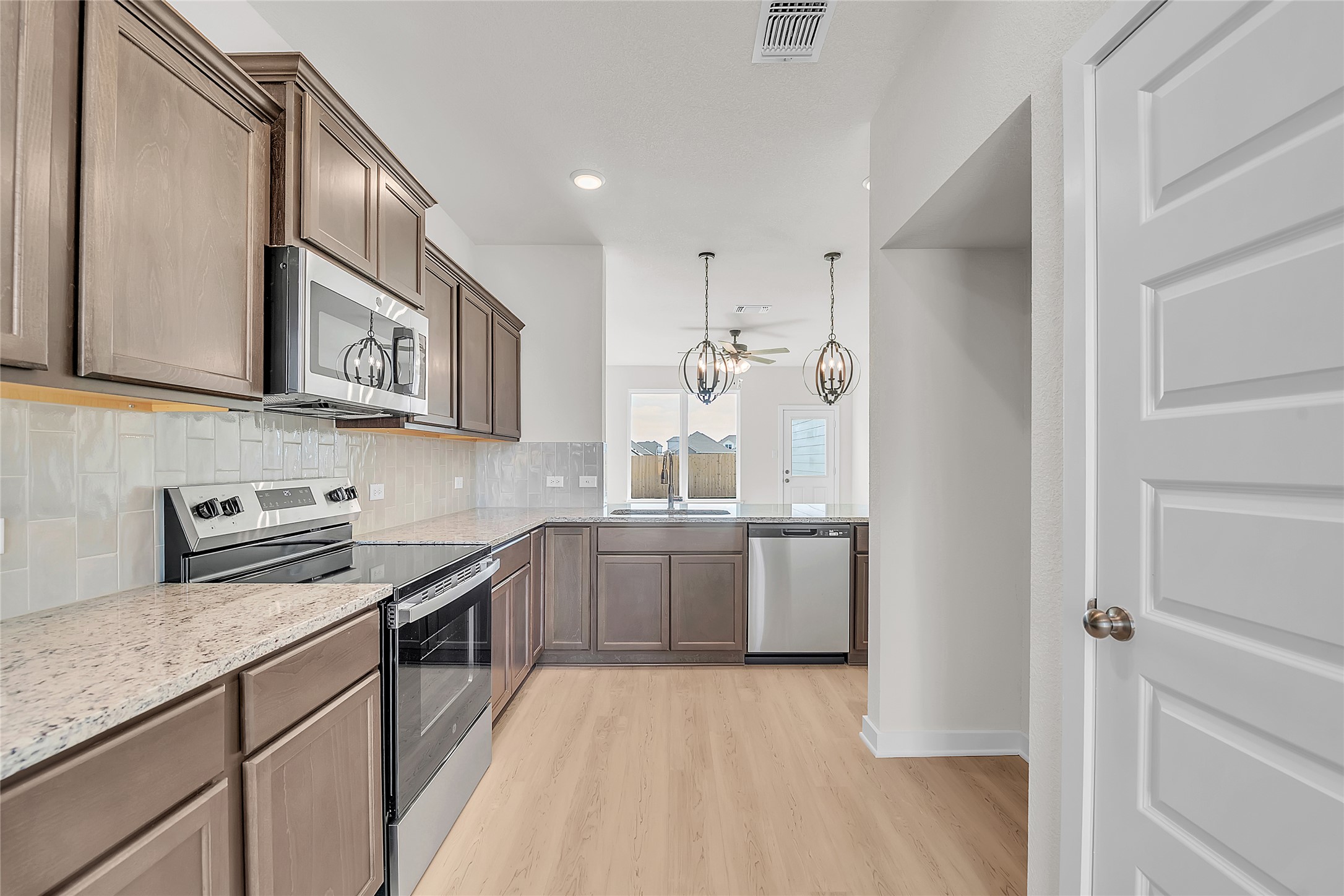 308 Boatright Boulevard Jarrell, TX 76537 - Photo 29 of 31 Kitchen featuring stainless steel appliances, light stone countertops, pendant lighting, decorative backsplash, and recessed lighting