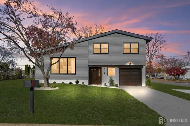 a front view of a house with a garden and yard