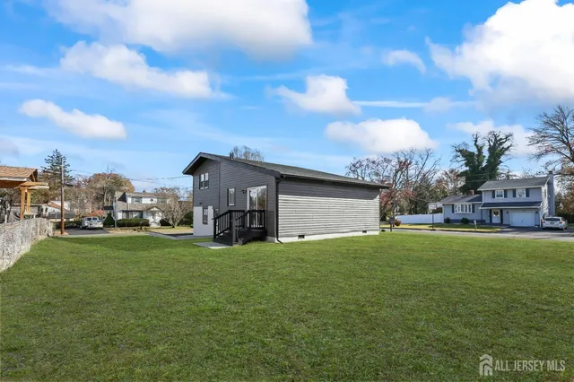 a view of a house with a big yard and large trees