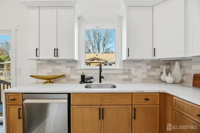 a kitchen with stainless steel appliances granite countertop a sink a stove and cabinets