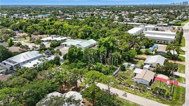 an aerial view of residential houses with outdoor space and trees