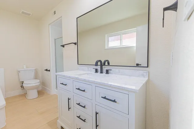 a bathroom with a toilet sink and mirror