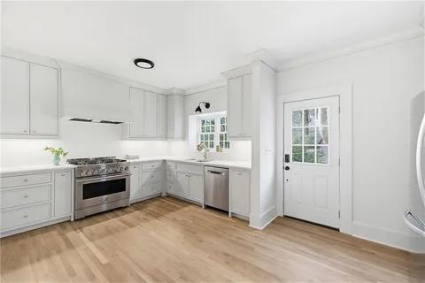 a kitchen with granite countertop white cabinets and stainless steel appliances