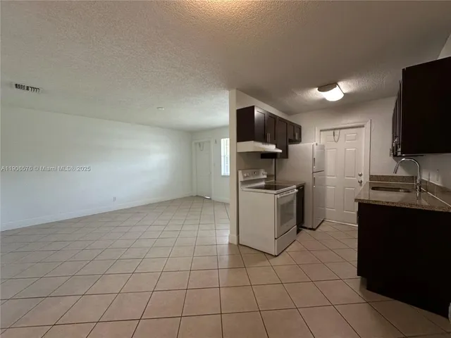 a kitchen with a sink a counter top space cabinets and stainless steel appliances