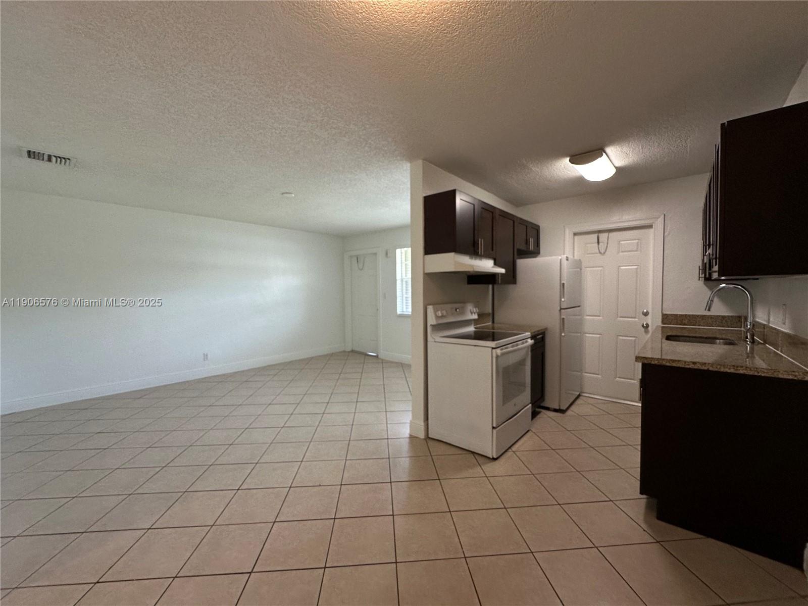 a kitchen with a sink a counter top space cabinets and stainless steel appliances