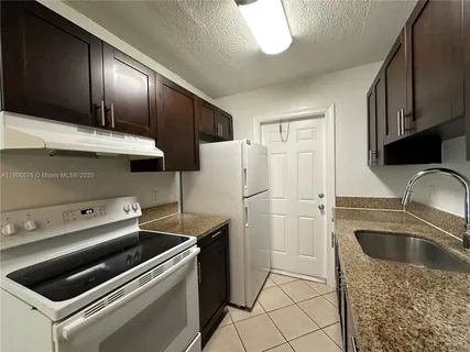a kitchen that has a sink cabinets counter space and stainless steel appliances