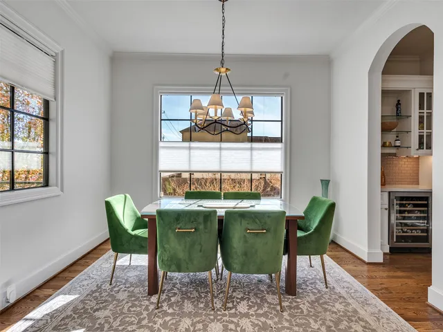 a dining room with furniture a chandelier and wooden floor