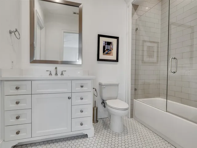 a bathroom with a bathtub toilet sink vanity and mirror