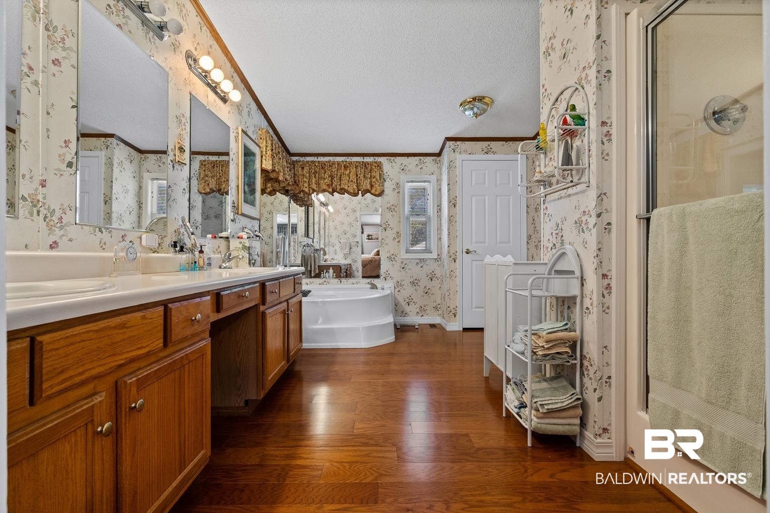 10647 Rte Road Lillian, AL 36549 - Photo 44 of 62 Bathroom with wallpapered walls, ornamental molding, a textured ceiling, wood finished floors, and a bath